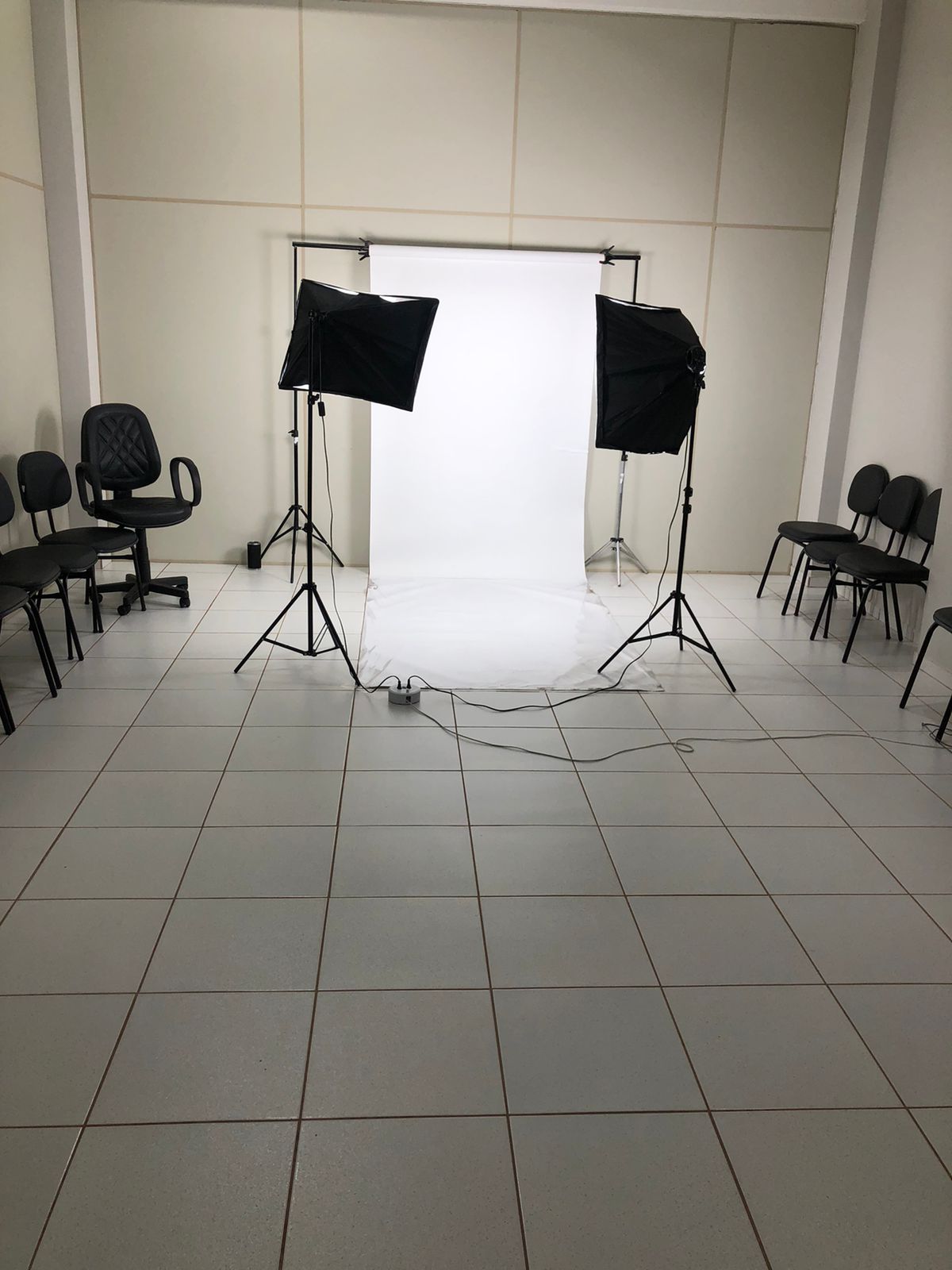 Estúdio com fundo infinito branco e iluminação profissional para gravações