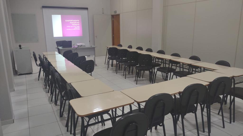Sala de treinamento montada em formato U com projetor e tela