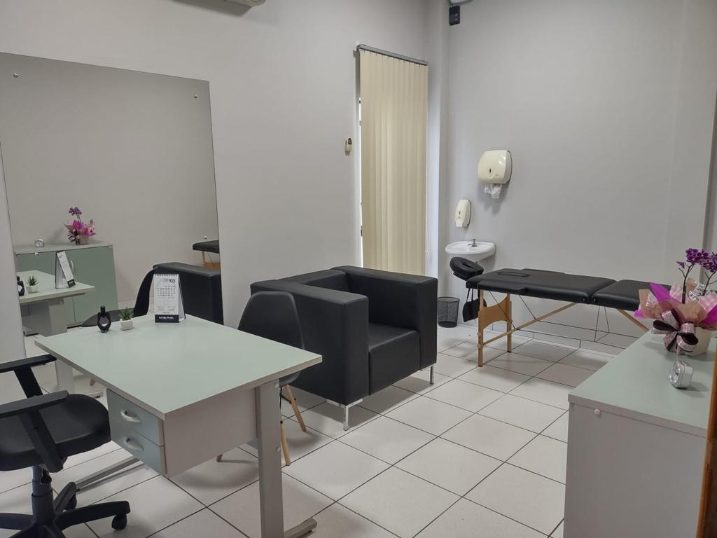 Sala multiuso com mesa de trabalho, poltrona e maca para atendimentos
