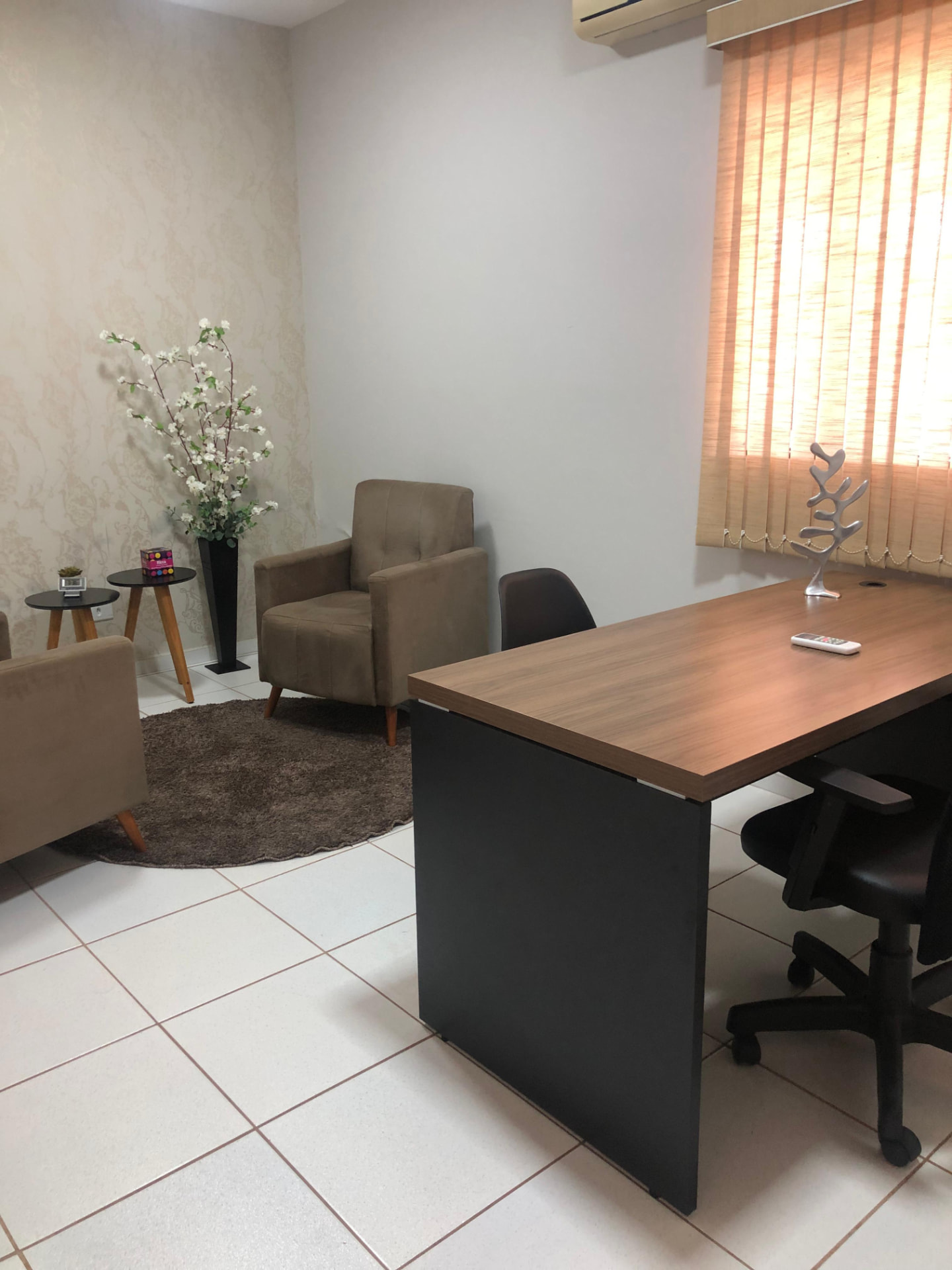 Sala privativa com mesa ampla, poltronas bege e decoração acolhedora